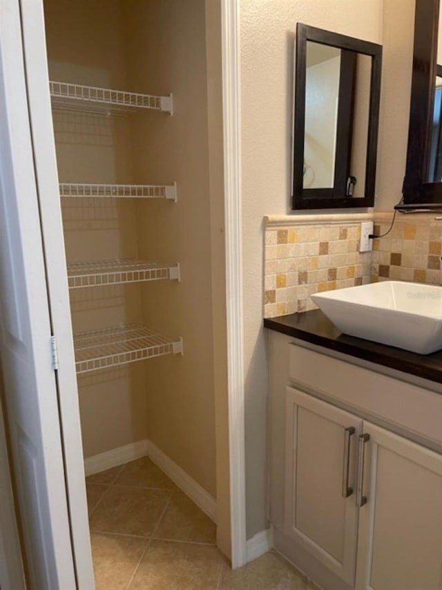 2950 Willowleaf Ln, Wesley Chapel, FL 33544 - bathroom with backsplash, baseboards, tile patterned flooring, and vanity