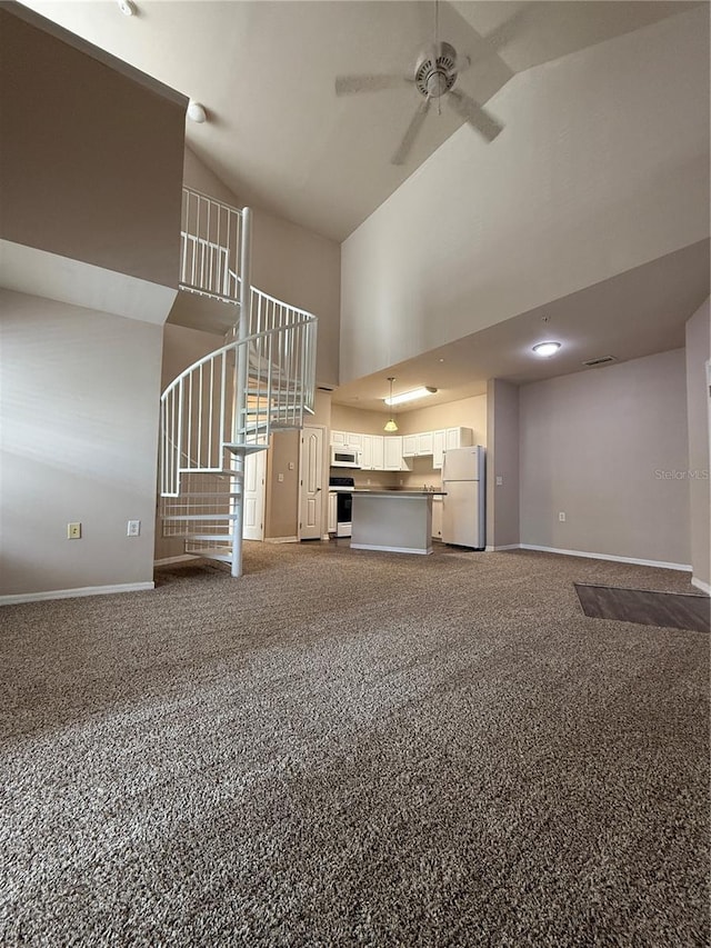 1530 Villa Capri Cir Unit 302, Odessa, FL 33556 - unfurnished living room with baseboards, ceiling fan, high vaulted ceiling, and stairway