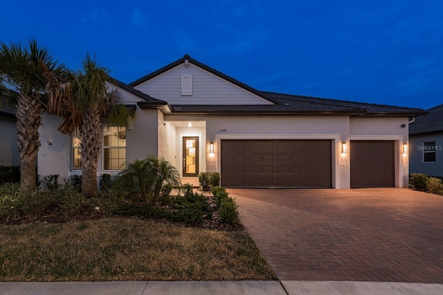 10982 Banyan Breeze Blvd, Land O Lakes, FL 34638 - view of front of home featuring a garage, stucco siding, and decorative driveway