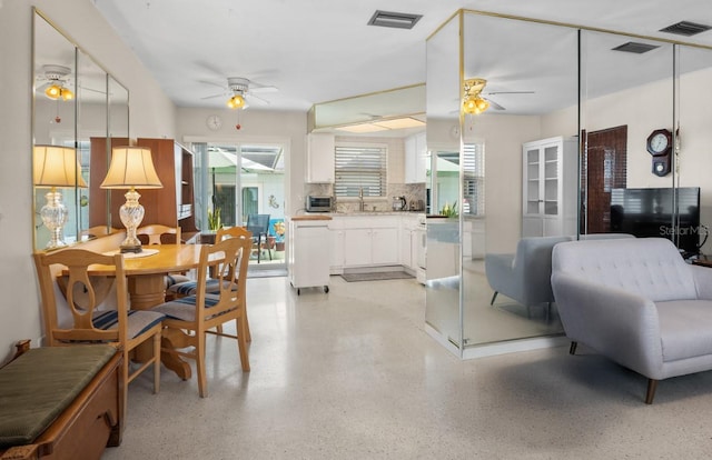 interior space with visible vents, ceiling fan, and light speckled floor