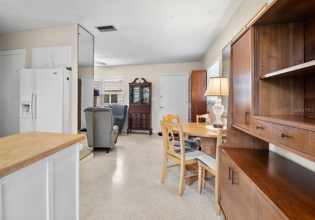 dining space featuring visible vents, a wealth of natural light, and light speckled floor