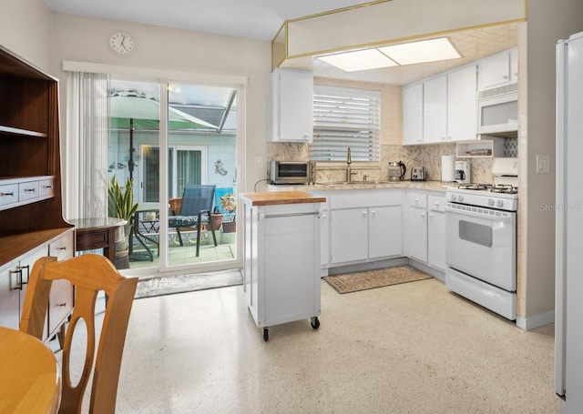 kitchen featuring a sink, white appliances, light countertops, white cabinetry, and tasteful backsplash