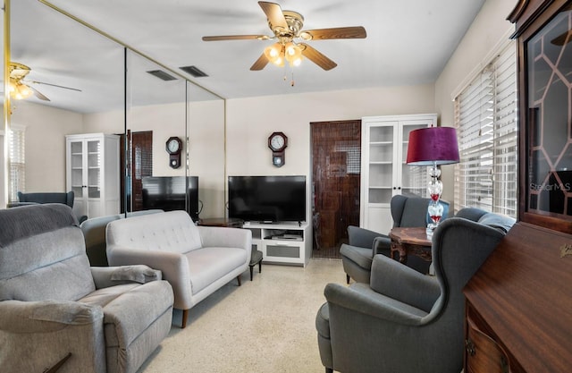 living area with a ceiling fan and visible vents