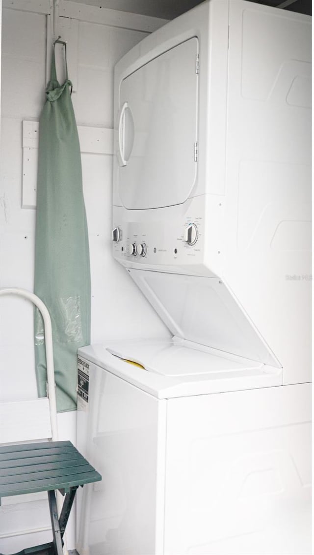 laundry room with stacked washer / drying machine and laundry area