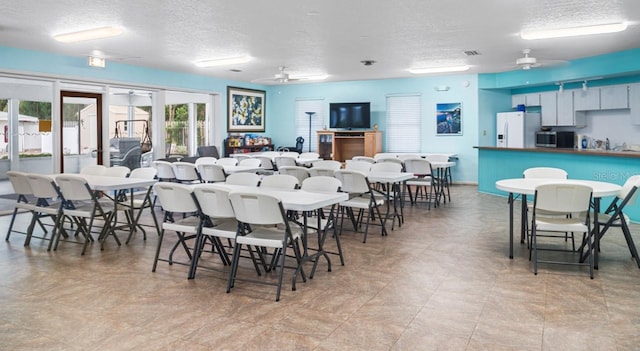 dining space with a textured ceiling and ceiling fan