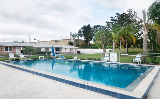 pool featuring a lawn and fence