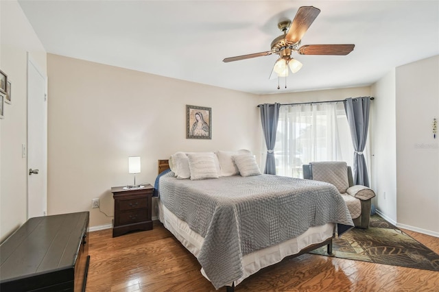 bedroom featuring baseboards, ceiling fan, and wood finished floors