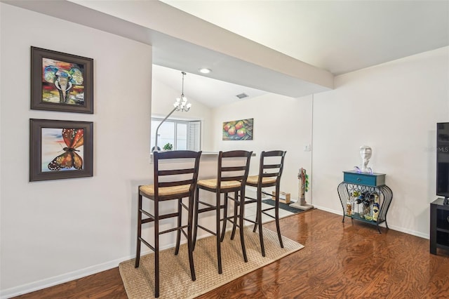 dining space featuring an inviting chandelier, baseboards, wood finished floors, vaulted ceiling, and visible vents