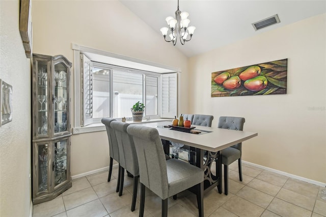 tiled dining area with visible vents, baseboards, a notable chandelier, and vaulted ceiling