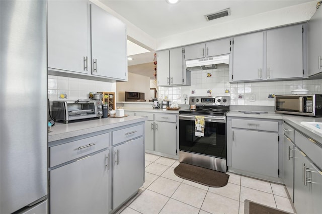 kitchen featuring appliances with stainless steel finishes, visible vents, a toaster, under cabinet range hood, and gray cabinetry