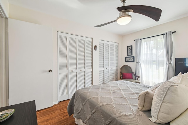 bedroom with multiple closets, ceiling fan, and wood finished floors