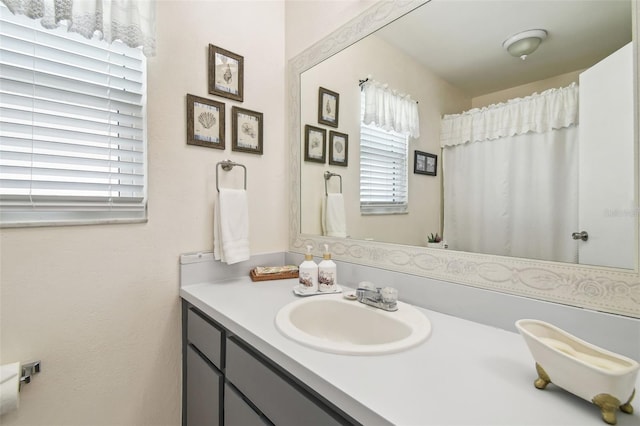 full bathroom featuring a healthy amount of sunlight and vanity