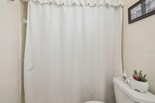 full bathroom featuring toilet and a shower with shower curtain