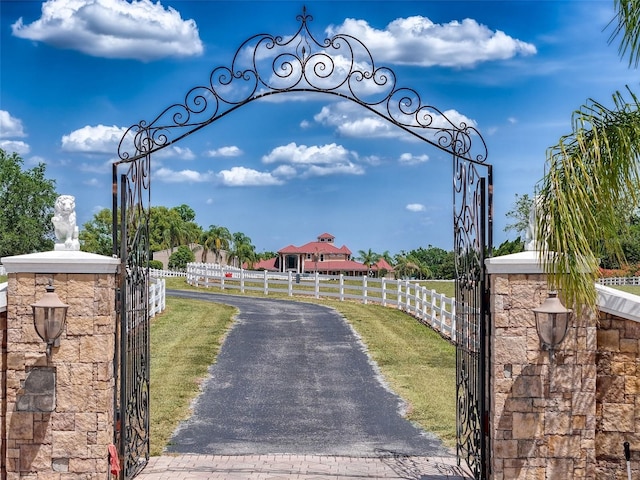 view of street with a gated entry, a gate, and aphalt driveway