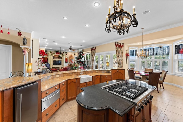 kitchen featuring brown cabinetry, a sink, a warming drawer, stainless steel appliances, and light tile patterned flooring
