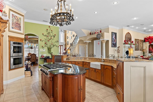 kitchen featuring a sink, light tile patterned floors, stainless steel appliances, and a large island
