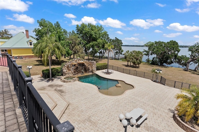 view of pool featuring a water view, a patio area, fence, and a pool with connected hot tub