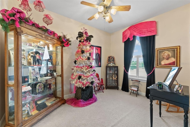 carpeted home office featuring baseboards and ceiling fan