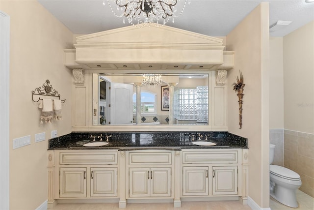 full bathroom with an inviting chandelier, toilet, and a sink