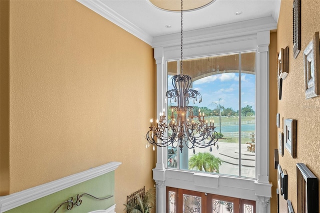 details with crown molding, a textured wall, and a chandelier