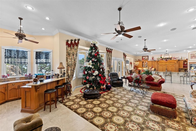 living area with recessed lighting, a ceiling fan, light tile patterned floors, and ornamental molding
