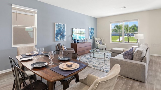 living area with baseboards, wood finish floors, and visible vents