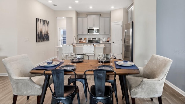 dining area featuring baseboards, recessed lighting, and light wood-type flooring