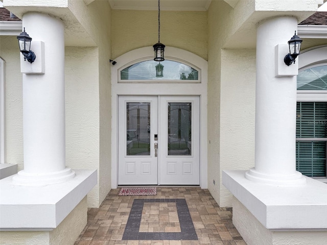 property entrance featuring stucco siding and french doors