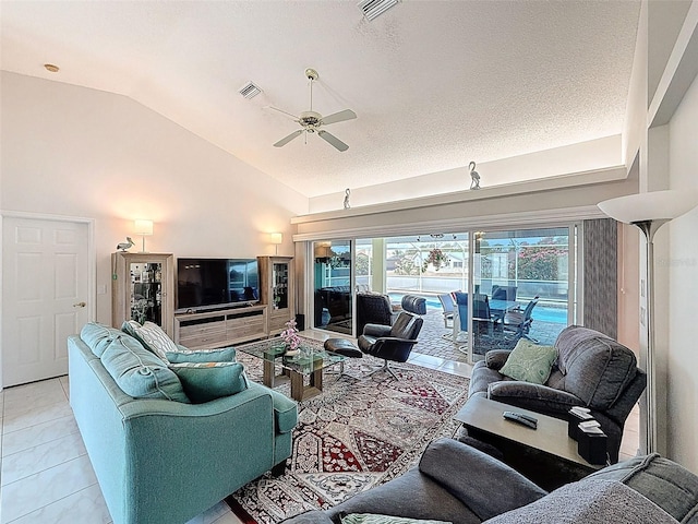 living area with light tile patterned floors, a ceiling fan, vaulted ceiling, and visible vents