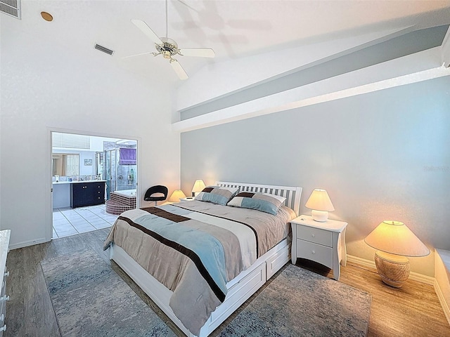 bedroom featuring light wood-style flooring, baseboards, high vaulted ceiling, and visible vents
