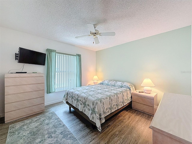 bedroom with baseboards, a textured ceiling, a ceiling fan, and wood finished floors