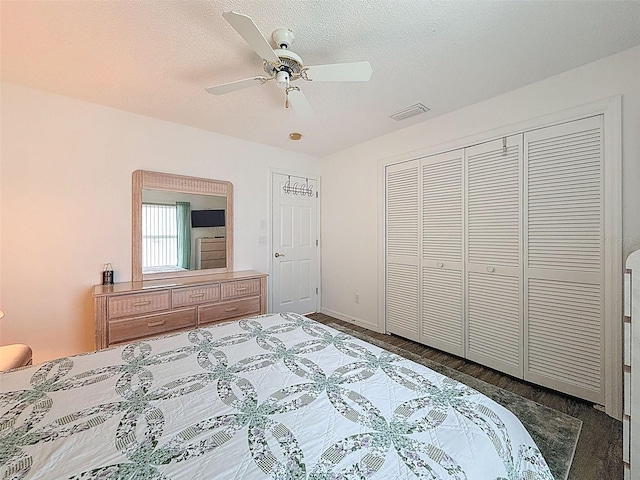 bedroom with ceiling fan, a closet, visible vents, and wood finished floors