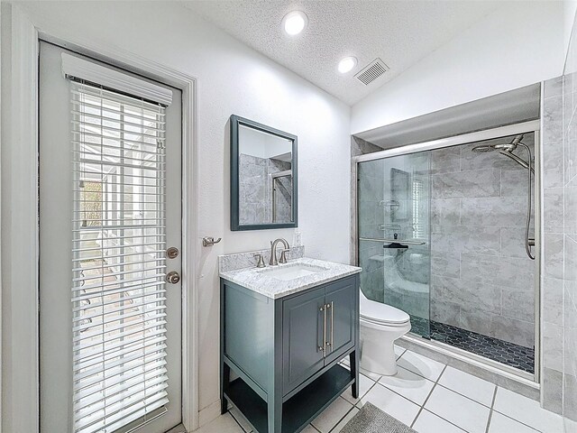 bathroom with a stall shower, a textured ceiling, visible vents, tile patterned flooring, and vanity