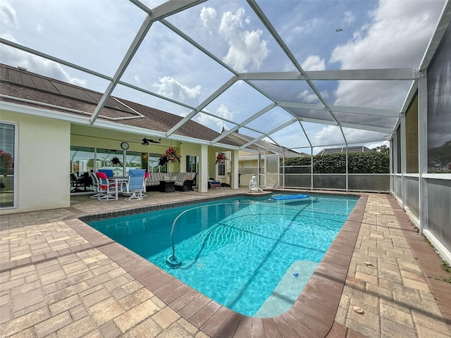 pool with ceiling fan, a patio, outdoor lounge area, and glass enclosure