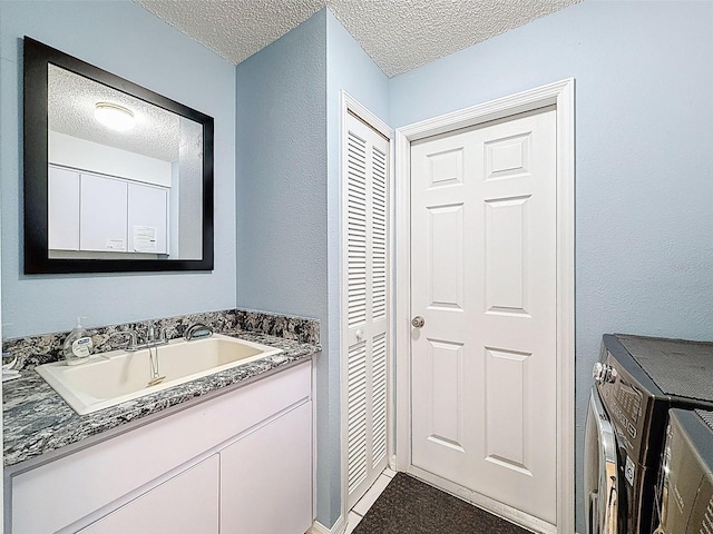 bathroom with a textured ceiling and vanity