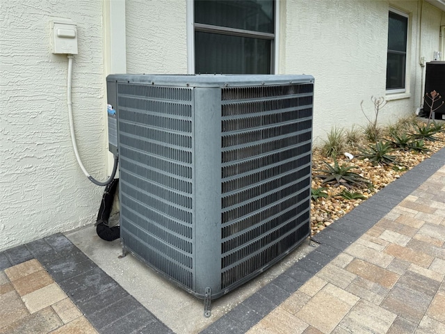 details featuring cooling unit and stucco siding
