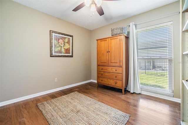 bedroom featuring baseboards and dark wood-type flooring