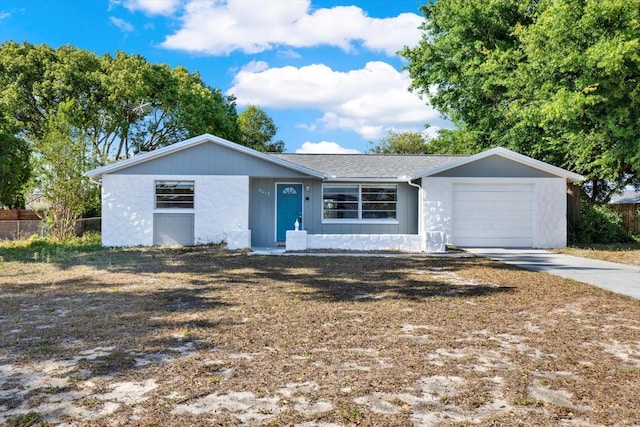 ranch-style house with a garage, fence, and driveway