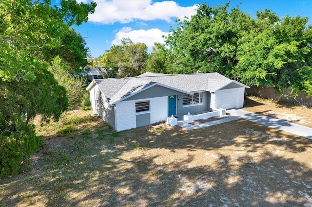 view of front of home with an attached garage, roof with shingles, fence, and driveway