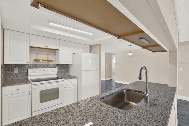 kitchen with a sink, white appliances, dark stone countertops, white cabinetry, and dark wood-style floors