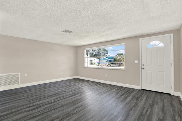 entrance foyer with visible vents, a textured ceiling, dark wood-type flooring, and baseboards