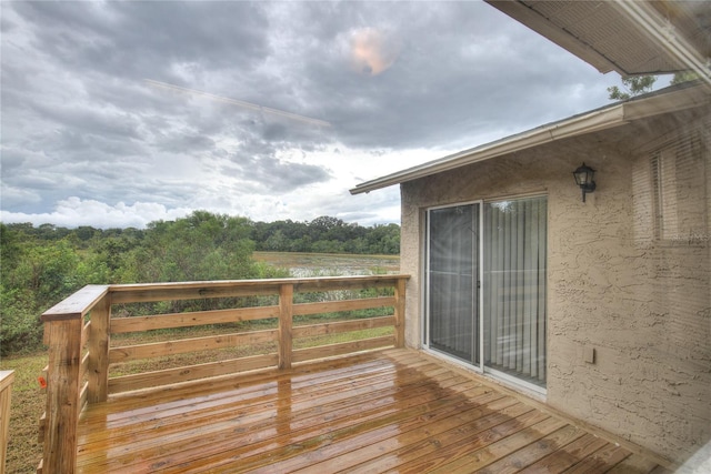 wooden terrace featuring a forest view