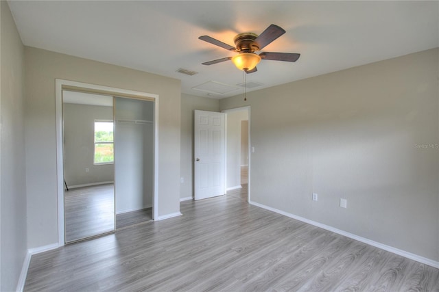 empty room with baseboards, a ceiling fan, wood finished floors, and visible vents