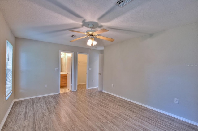 empty room with visible vents, light wood-style flooring, ceiling fan, and baseboards