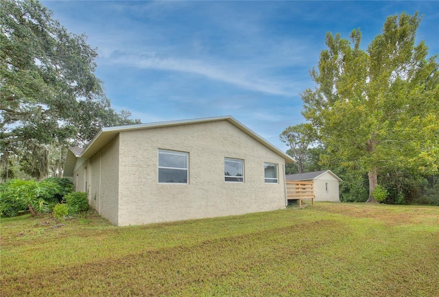 view of side of property featuring a lawn and stucco siding