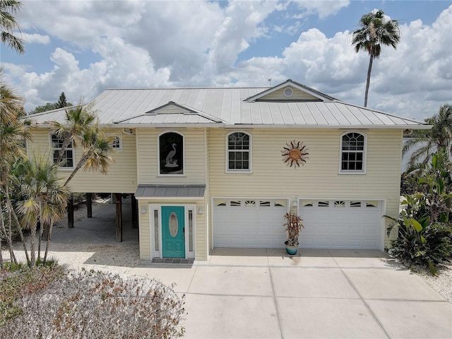 view of front of home with concrete driveway, an attached garage, a standing seam roof, and metal roof