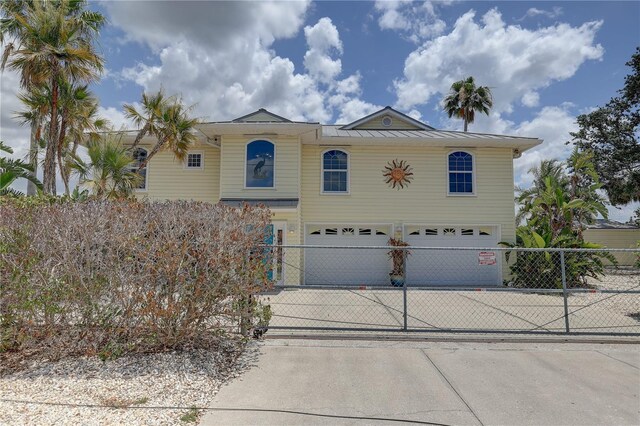 view of front of home featuring a garage, fence, and driveway