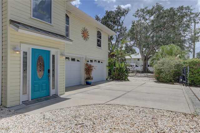 view of property exterior with concrete driveway and a garage