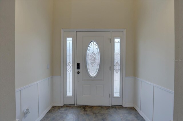 foyer entrance featuring a decorative wall and a wainscoted wall