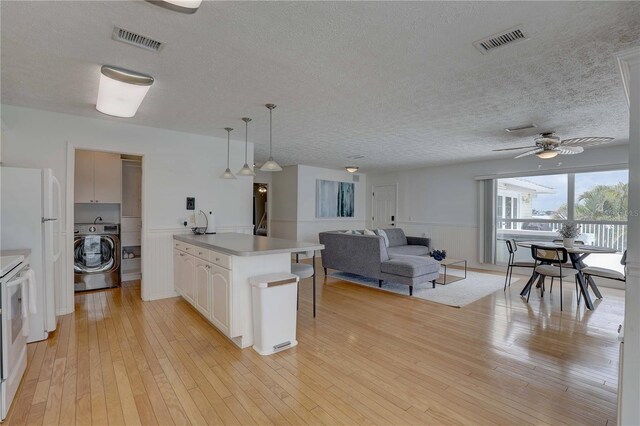 kitchen with visible vents, a textured ceiling, and washer / dryer